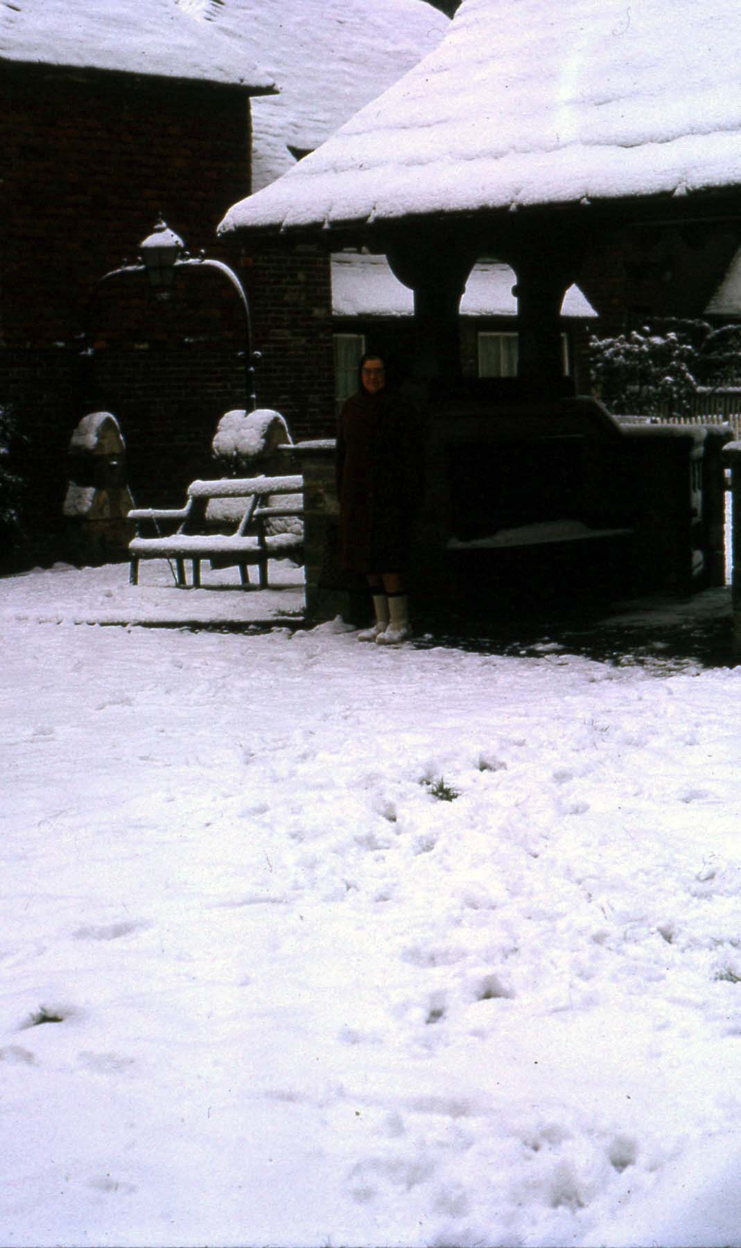 Snow rests heavily on the lych gate and cottages in Church Approach